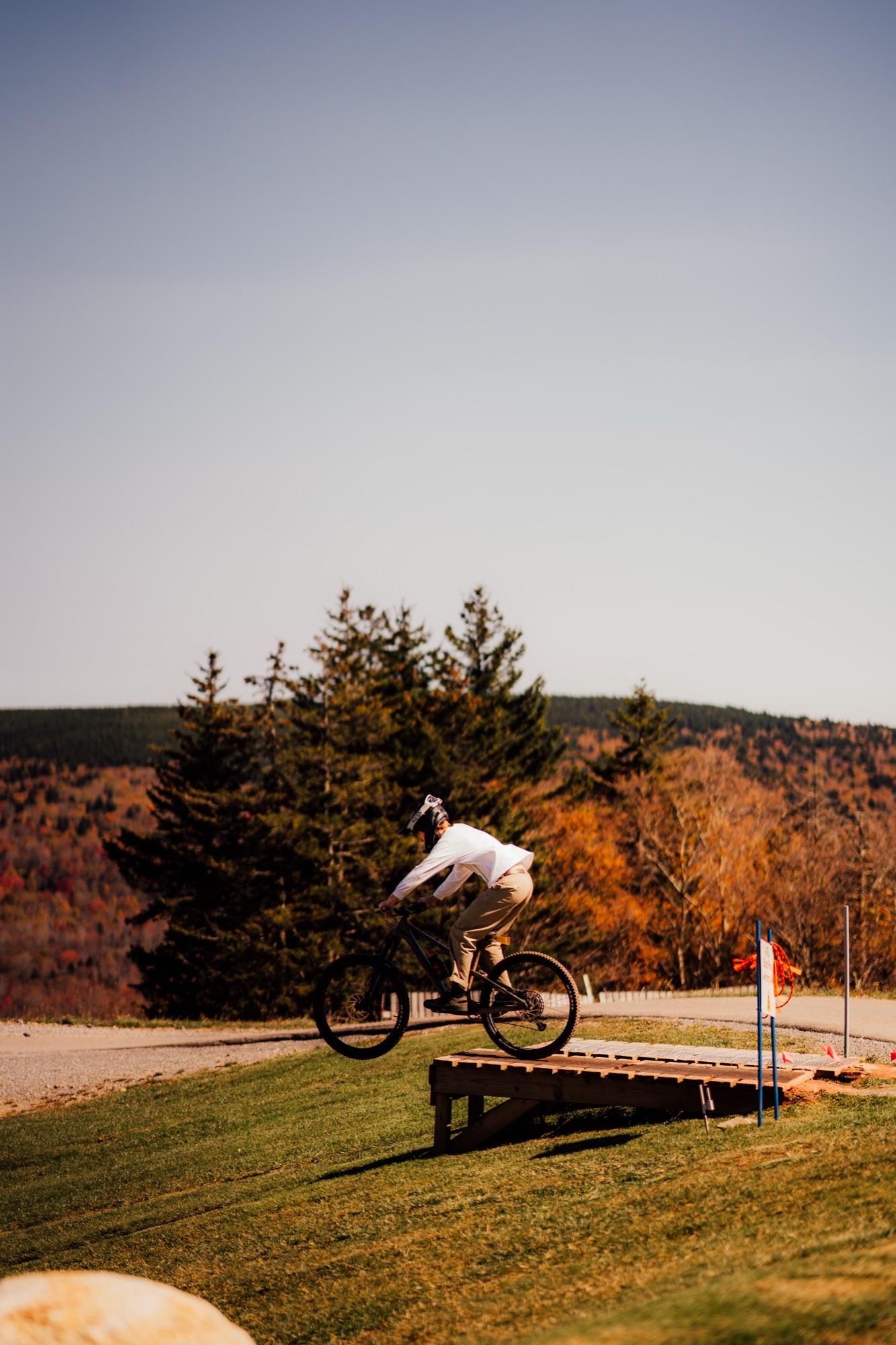 A rider sending a jump at the Snowshoe Bike Park under fall color