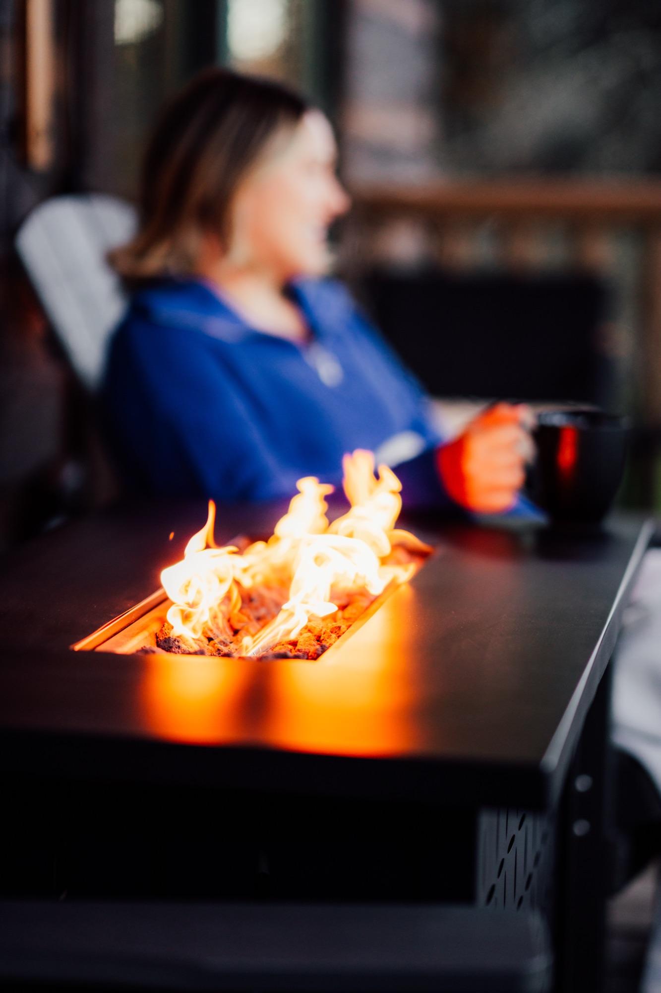 A mug by the fire pit at dusk on a Wander Luxe deck
