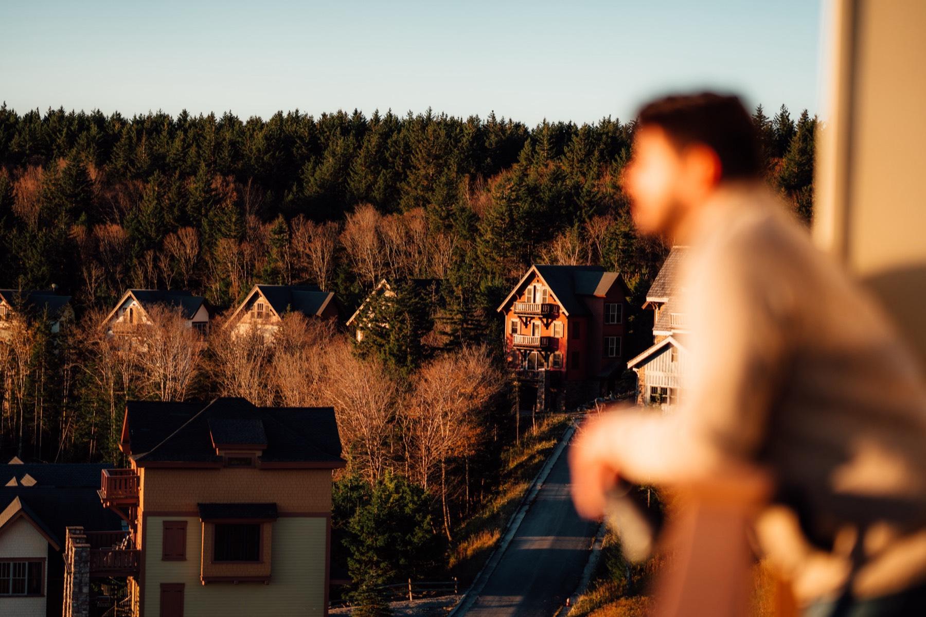 Austin on a deck above the Timbers homes at Snowshoe as the sun sets
