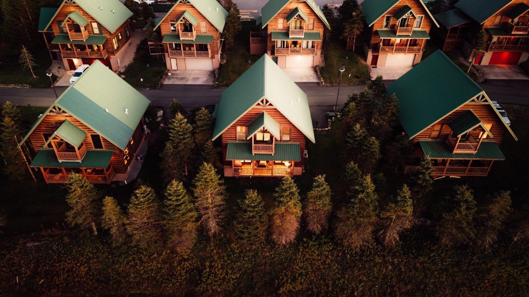 The Timbers neighborhood at dusk from above, cabins among the spruce