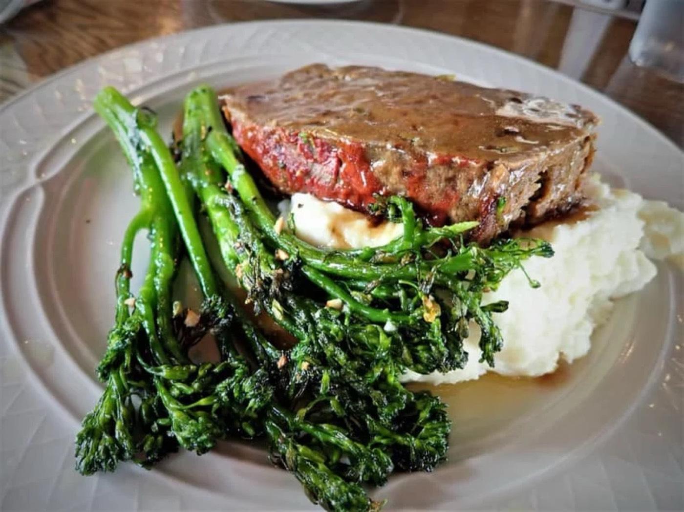 A plated entree with grilled broccolini and mashed potatoes at Appalachia Kitchen