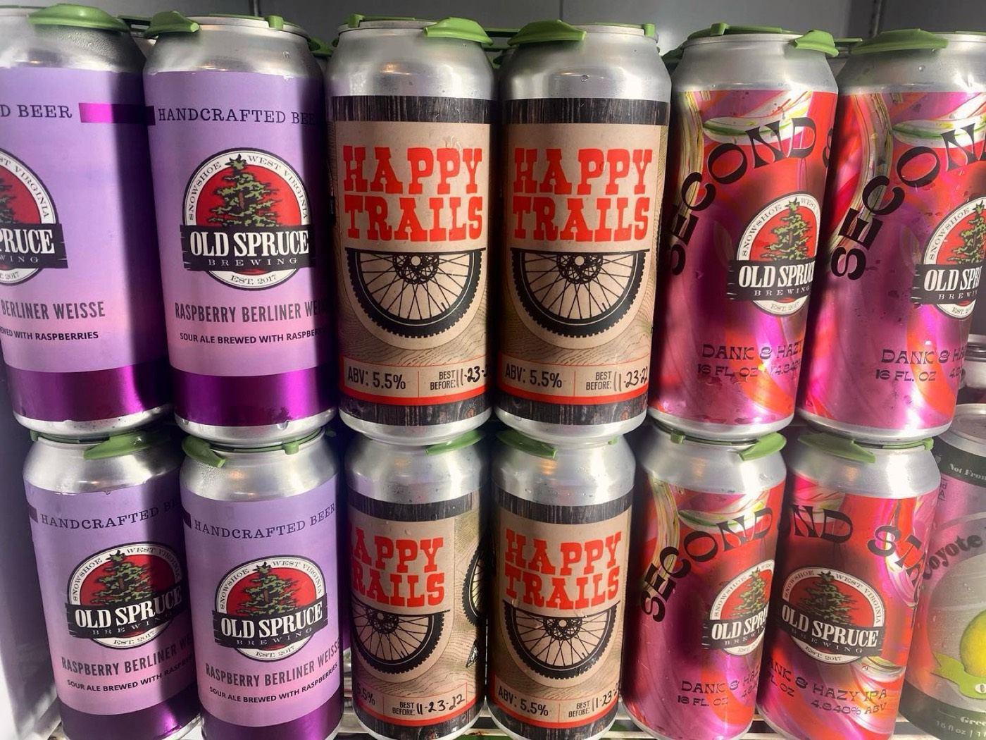 Cans of Old Spruce beer, including Happy Trails, stacked in a cooler at the brewery