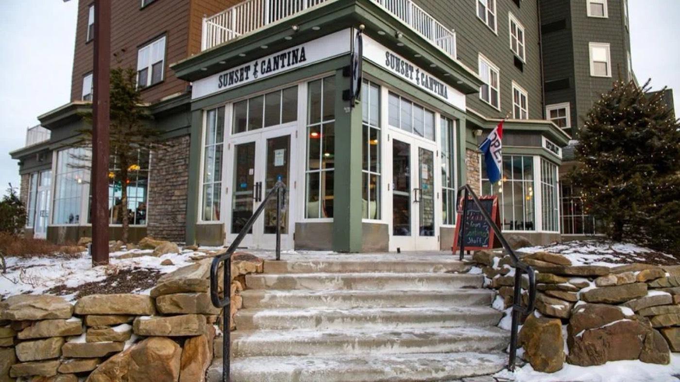 The Sunset Cantina storefront and stone steps in the Village with snow on the ground