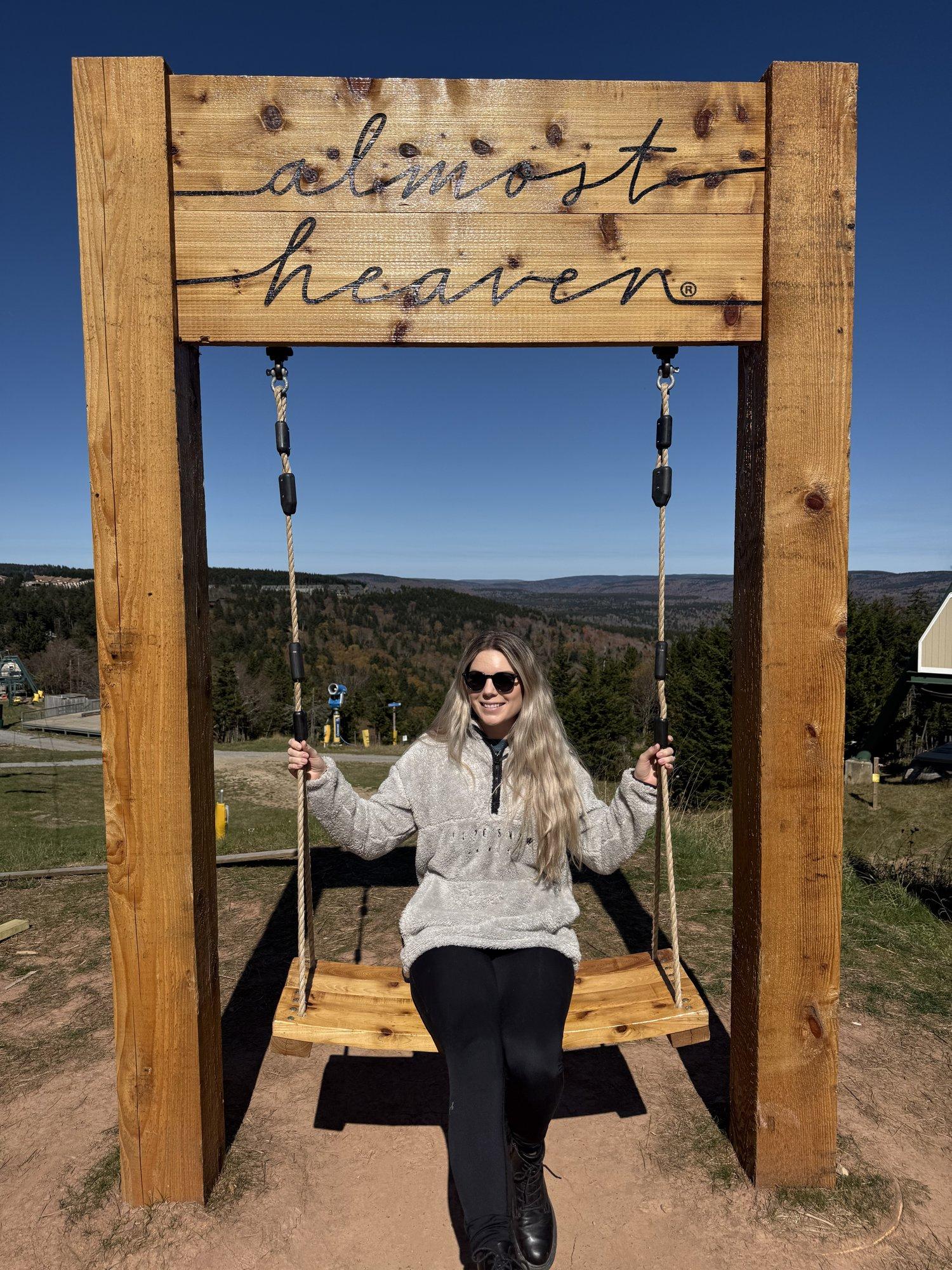 The Almost Heaven swing at the summit with fall color on the ridge behind it