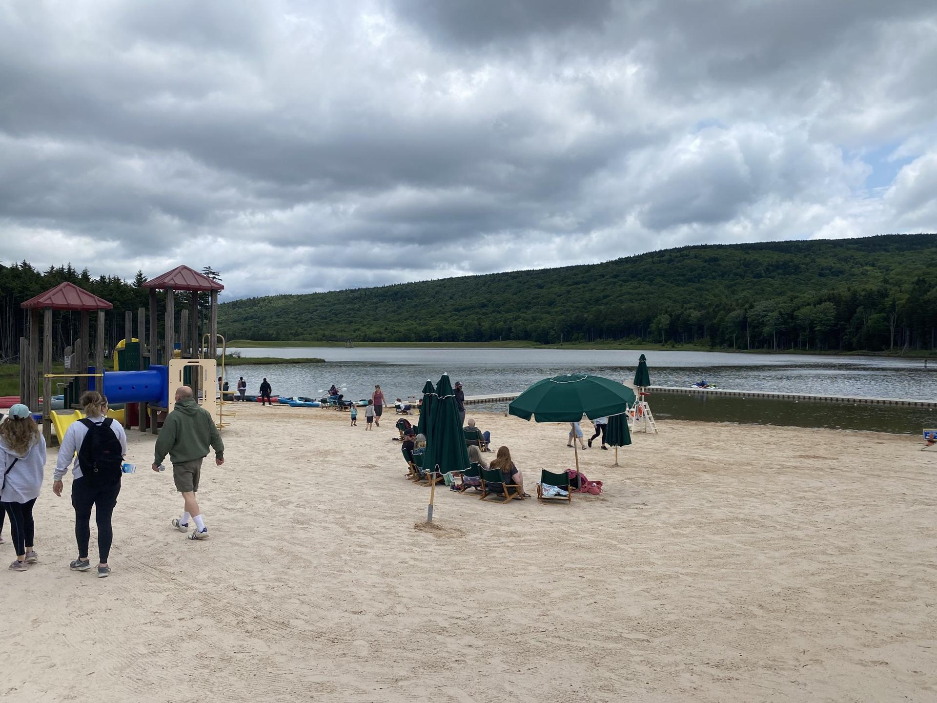 The sand beach at Shavers Lake on a summer afternoon, families on the shore
