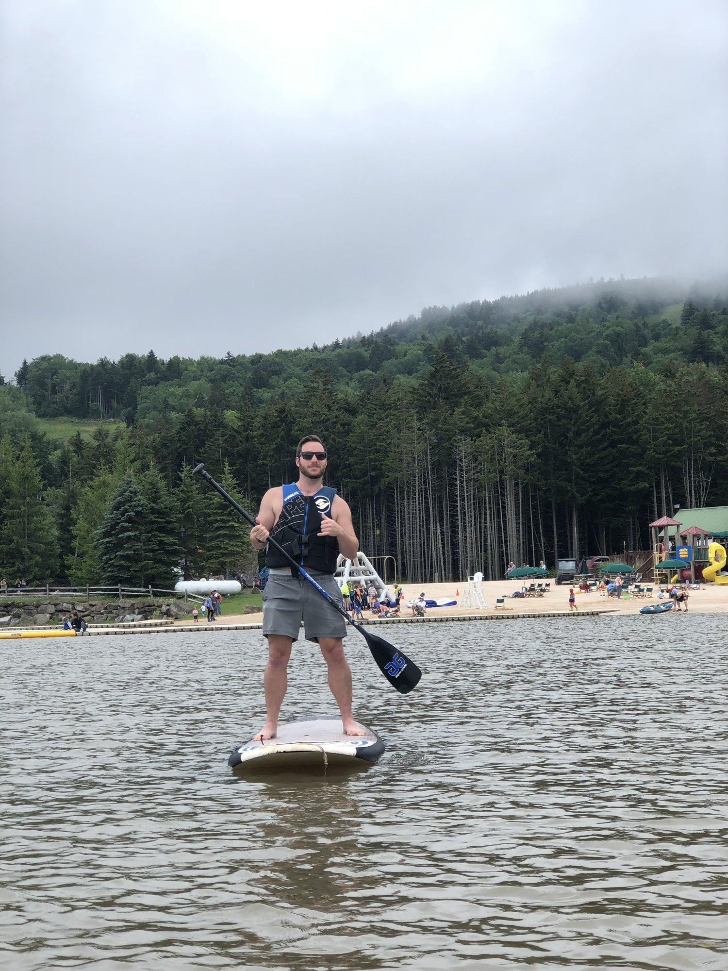 Paddleboarding across Shavers Lake with the treeline behind