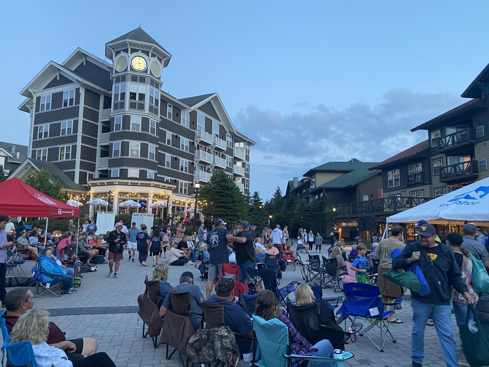 An outdoor concert crowd in the Village at Snowshoe on a summer evening